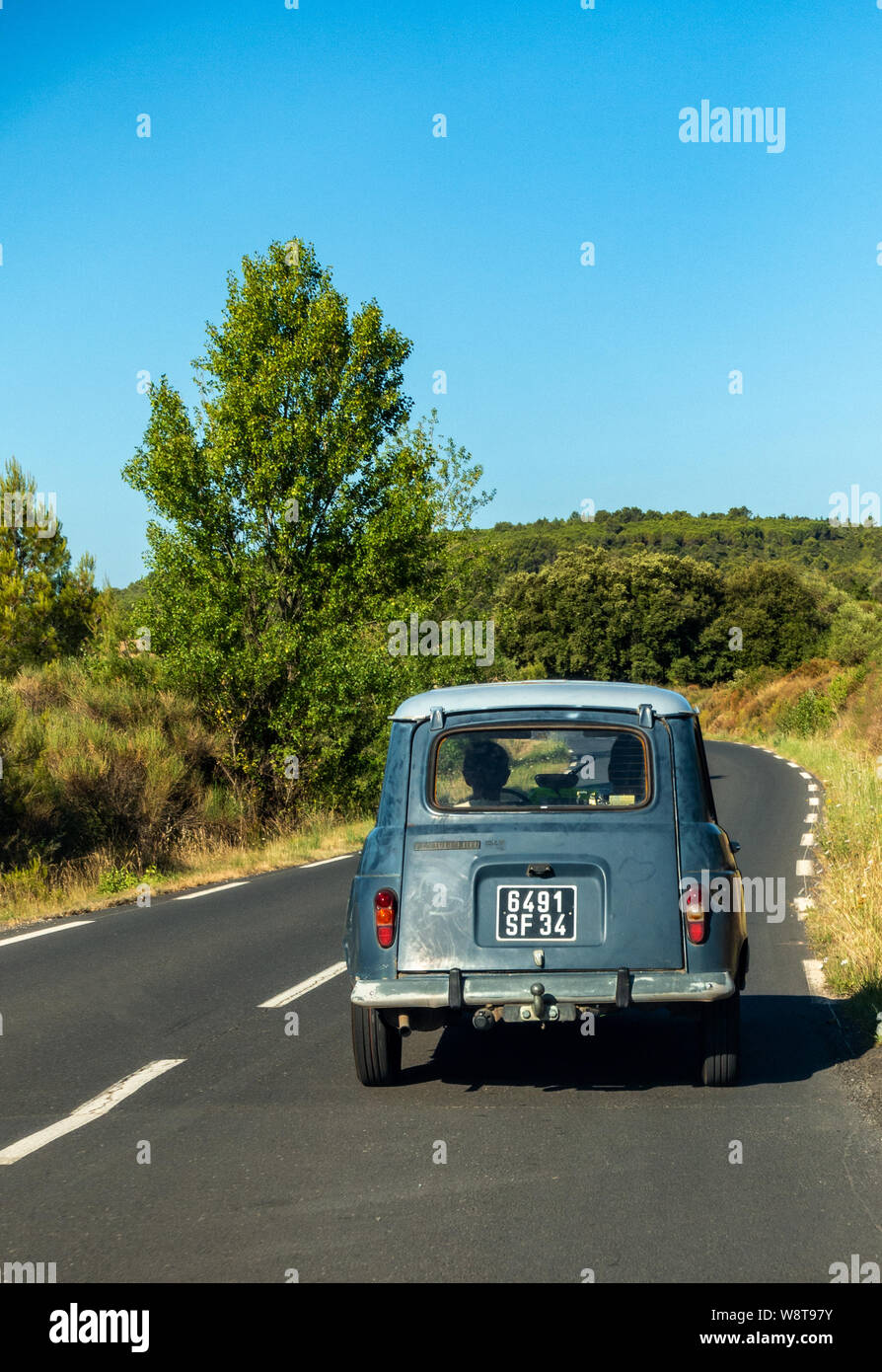 Classic Renault 4 TL auto guidando su una tranquilla strada francese Foto Stock