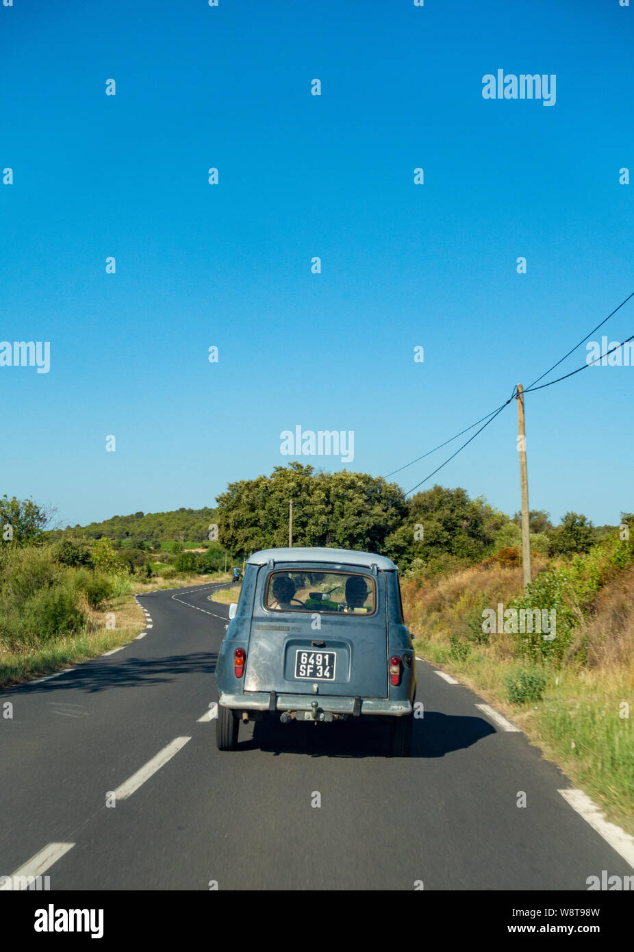 Classic Renault 4 TL auto guidando su una tranquilla strada francese Foto Stock