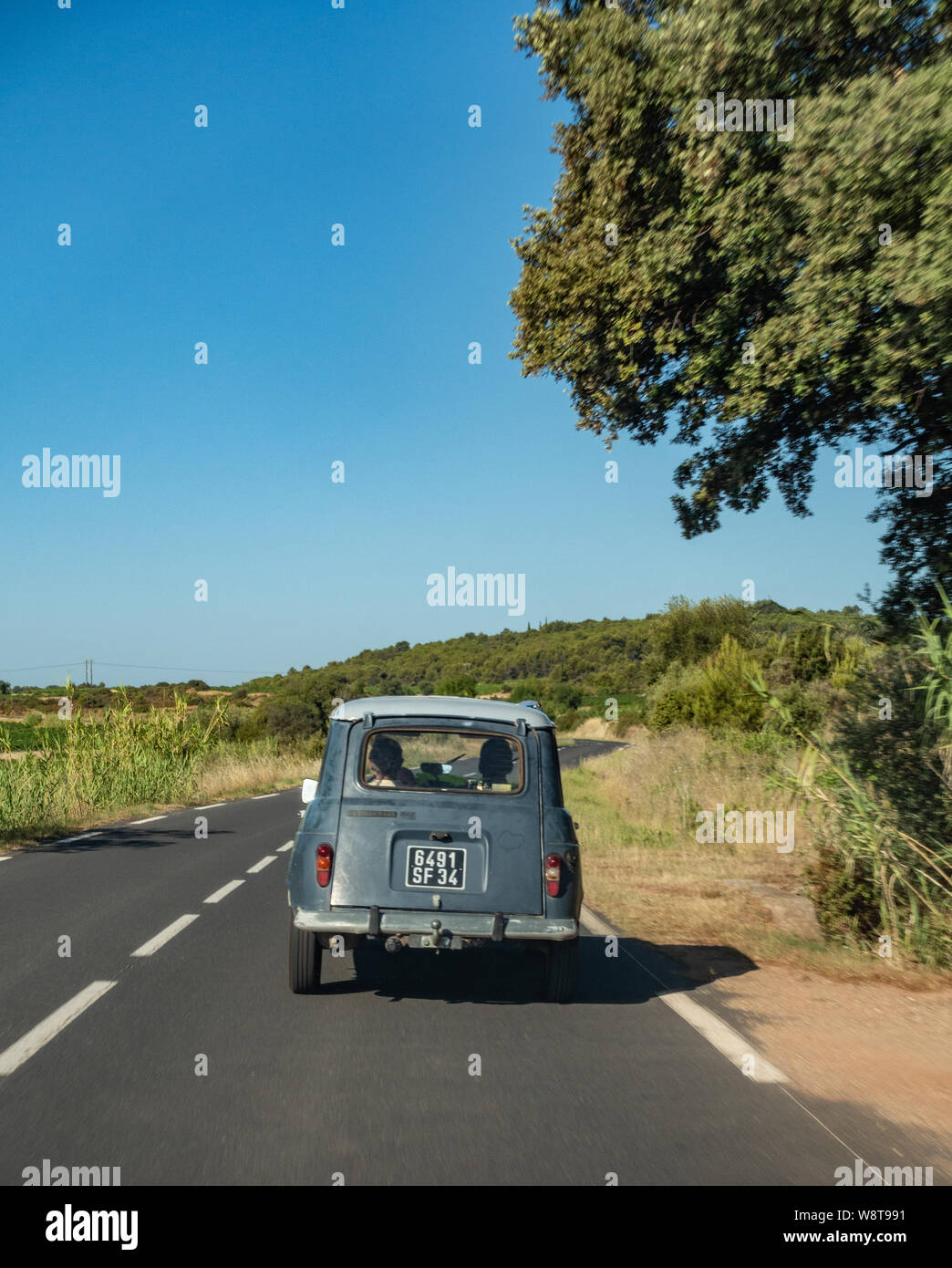 Classic Renault 4 TL auto guidando su una tranquilla strada francese Foto Stock