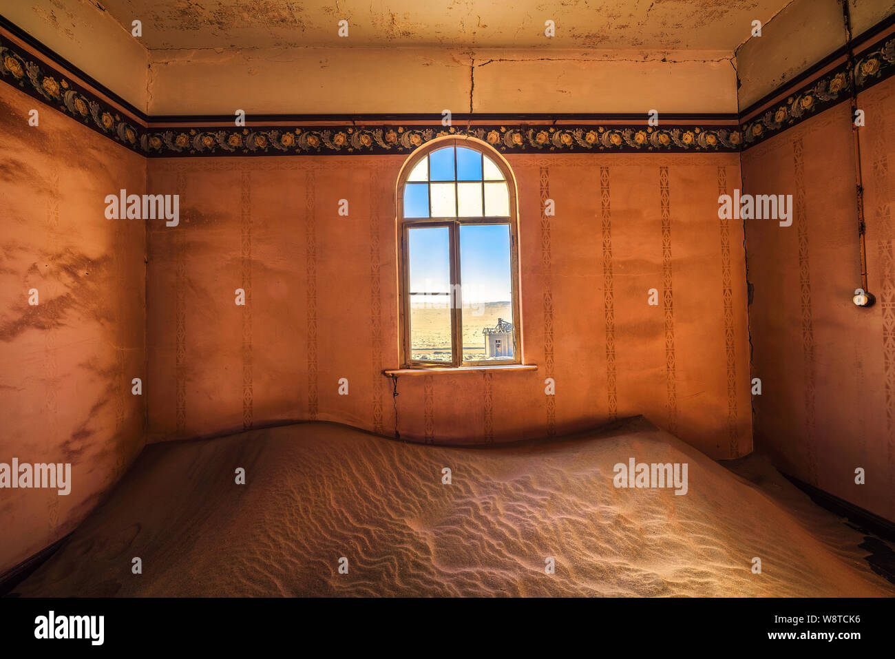 Stanza vuota con una finestra e la sabbia in le rovine di una città fantasma Kolmanskop, Namibia Foto Stock