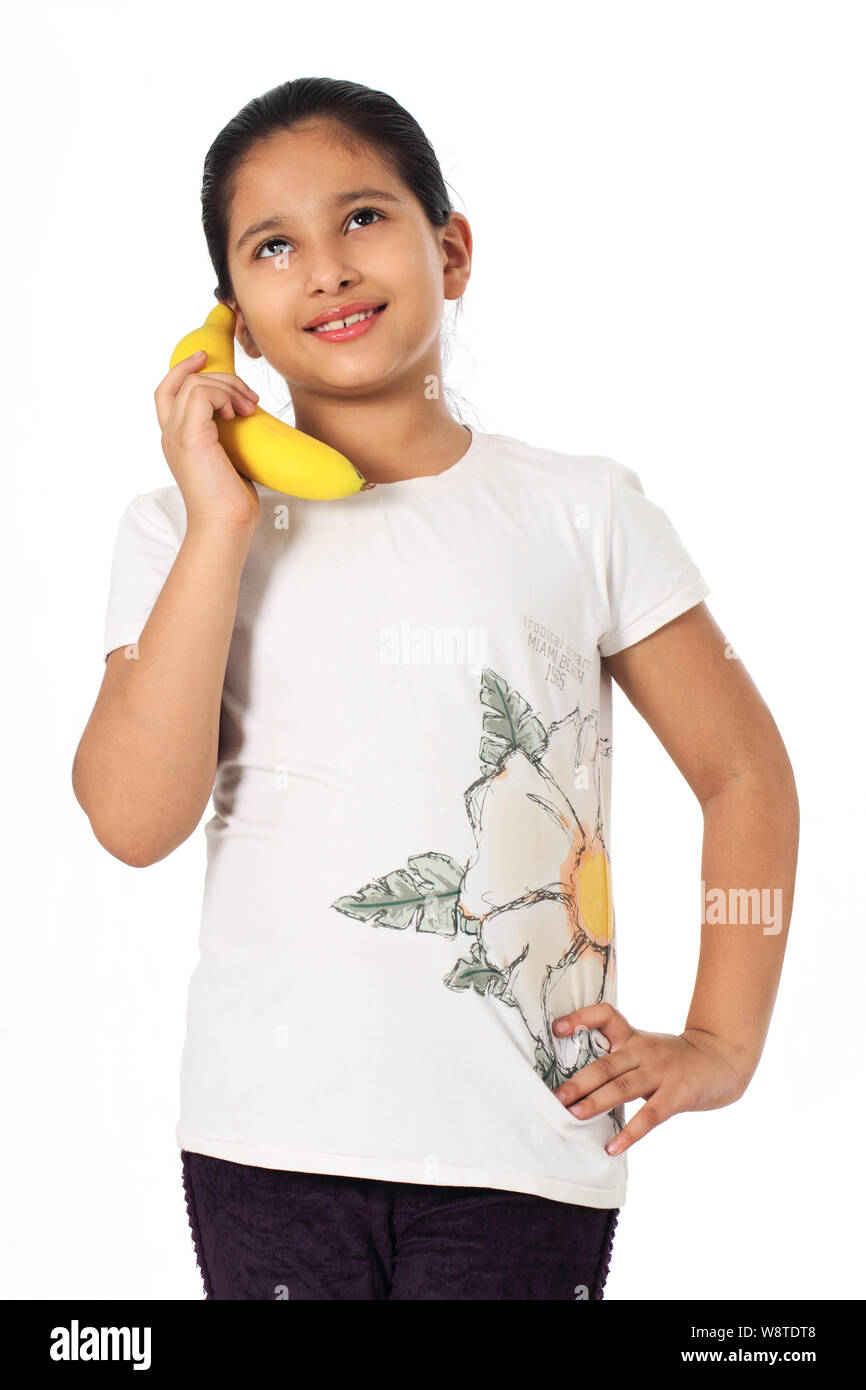 Ragazza con una banana come un telefono mobile Foto Stock