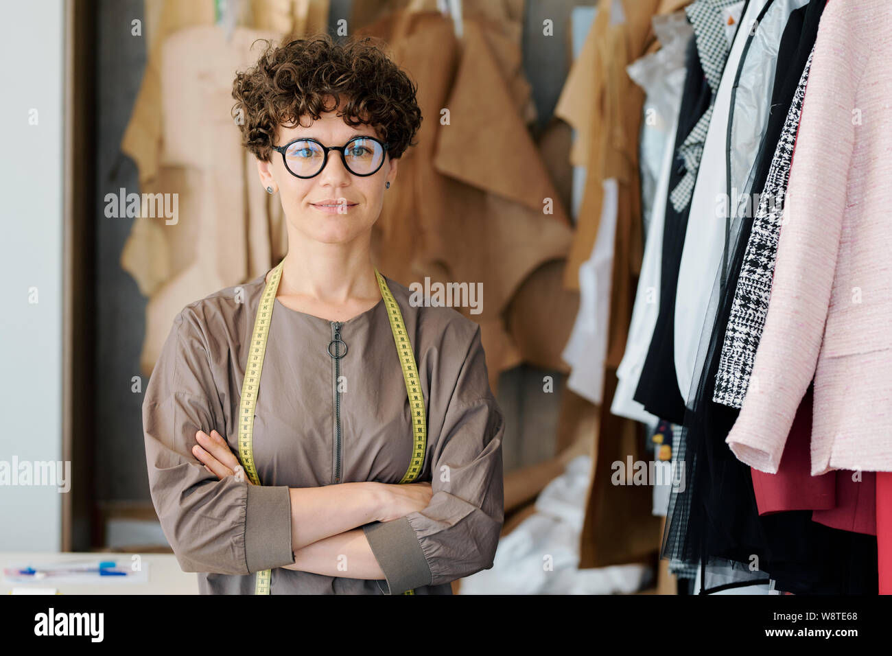 Giovane donna elegante in occhiali guardando a voi in studio di moda Foto Stock