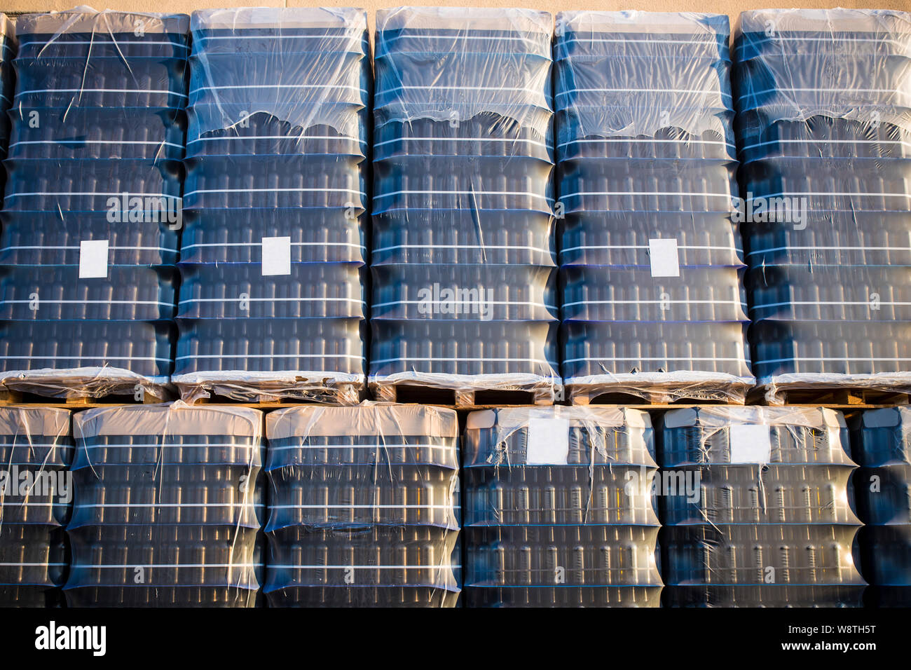 Un sacco di avvolto svuotare bottiglie di vino rosso su pallet. Prodotti  finiti di pulizia di bottiglie confezionate Foto stock - Alamy