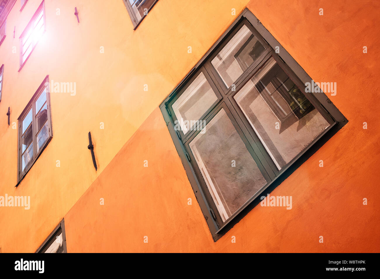 Parte della facciata di un marrone edificio storico illuminato, riflette i riquadri della finestra, nella vecchia città di Gamla Stan di Stoccolma, Svezia. Serie - st Foto Stock