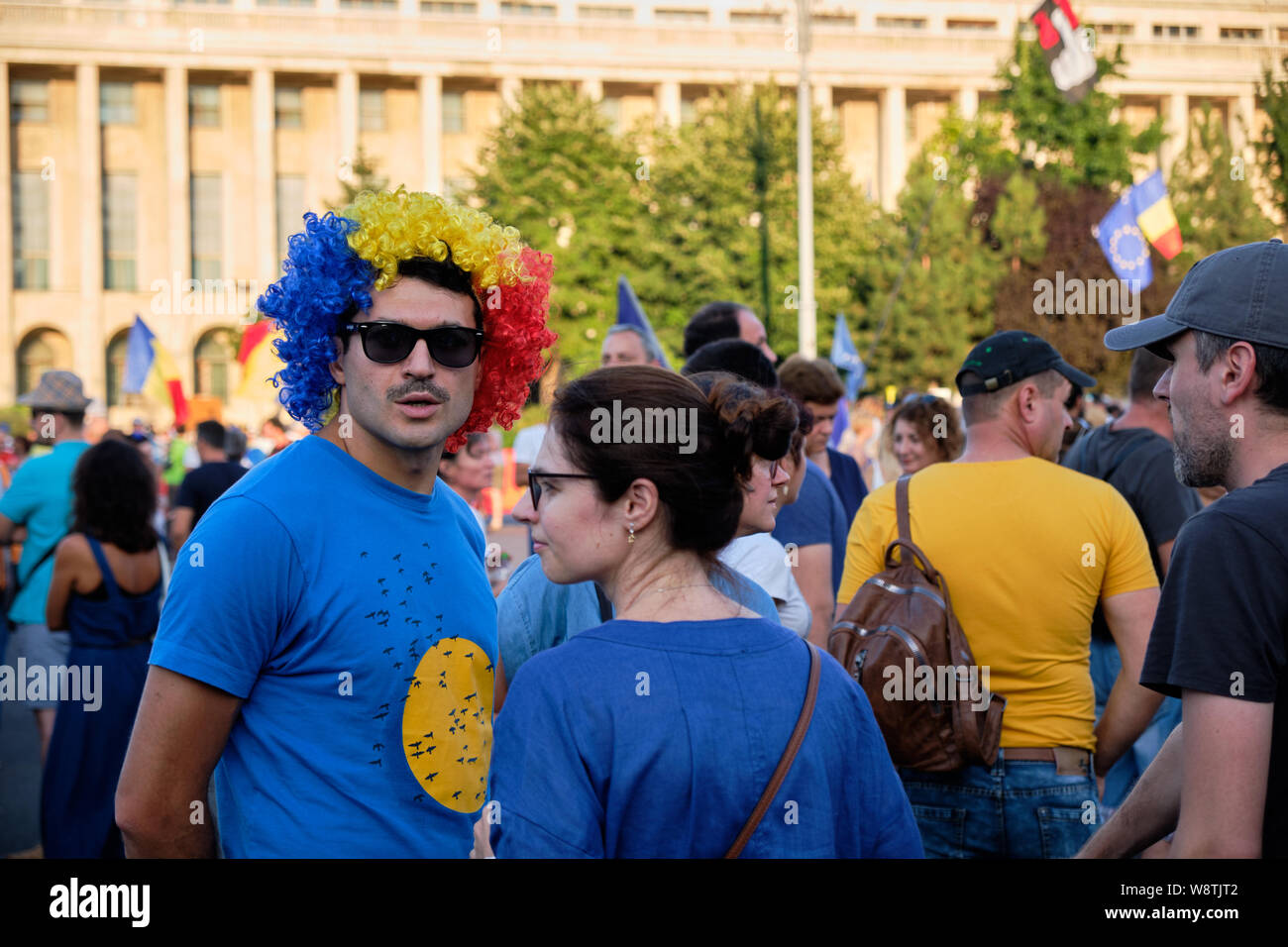 Protester con parrucca nei colori della bandiera rumena a protestare contro le accuse di corruzione in seno al governo della Romania a Bucarest Foto Stock