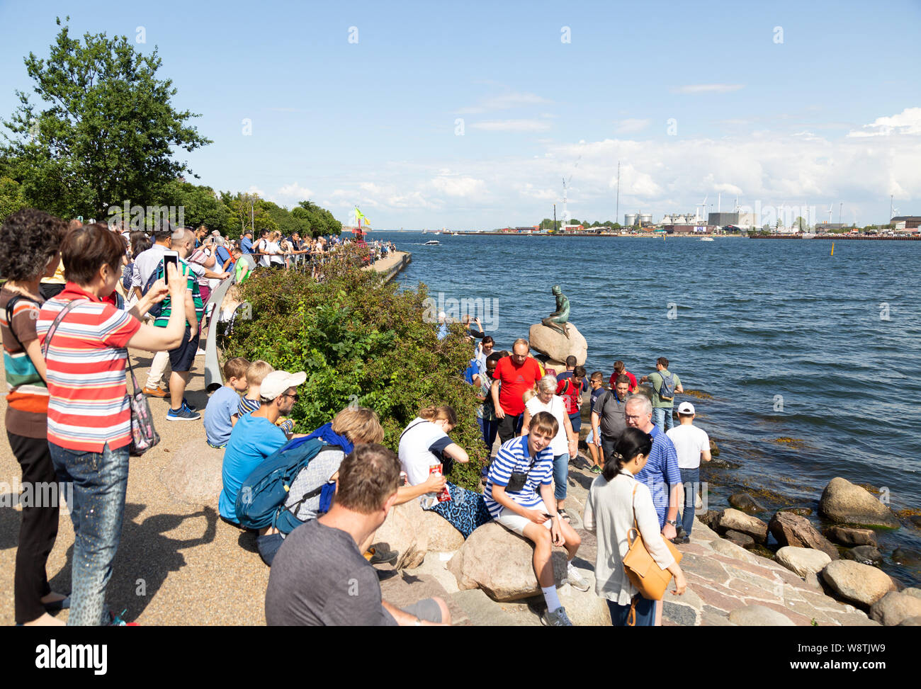 Viaggio Danimarca - persone affollate intorno a la famosa statua della Sirenetta, esempio di turismo danese; Copenhagen DANIMARCA e Scandinavia Europa Foto Stock