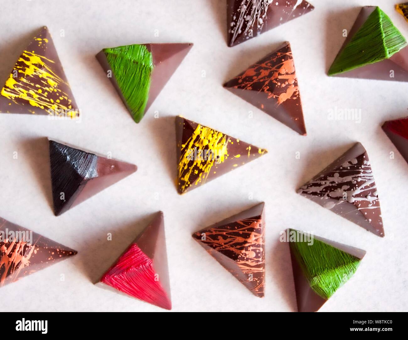 Cioccolato fondente praline colorate su sfondo bianco. Foto Stock