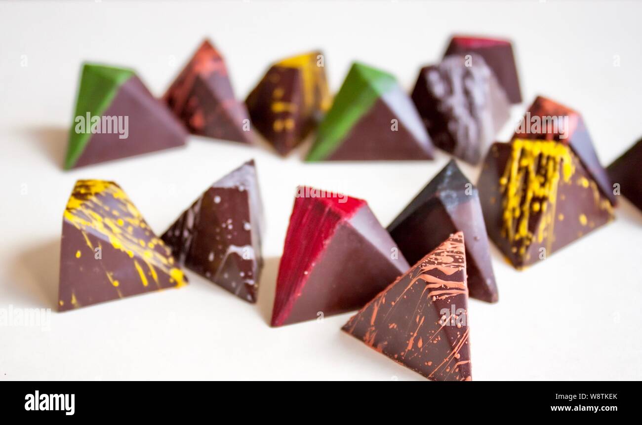 Cioccolato fondente praline colorate su sfondo bianco. Foto Stock