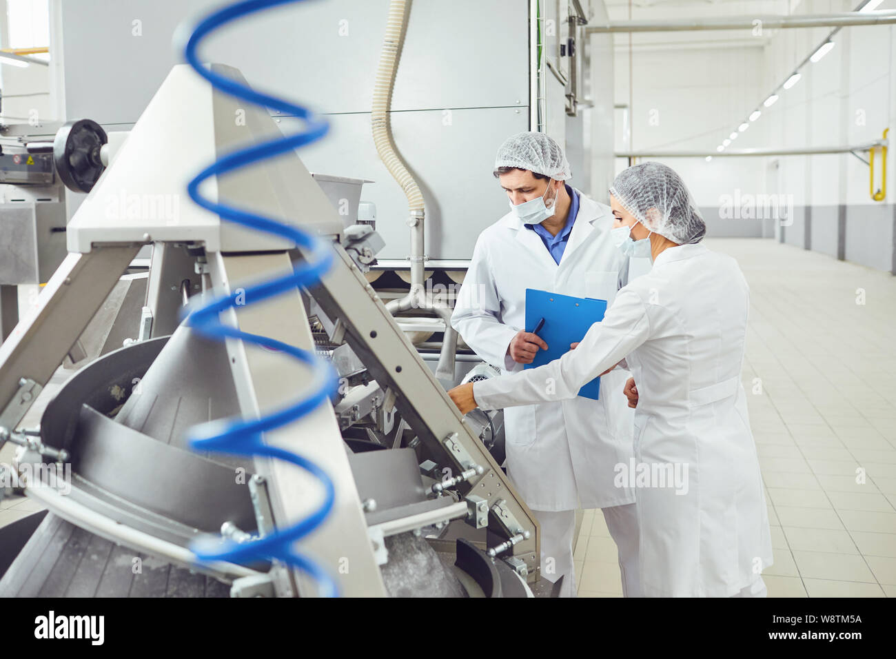 I tecnologi ispettore nelle maschere presso stabilimento alimentare. Foto Stock