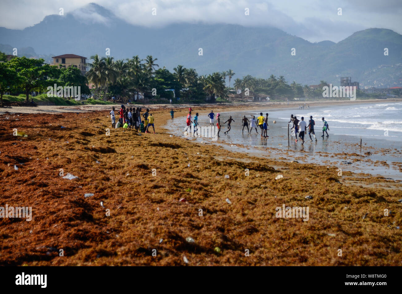 I calciatori su Lumley Beach a Freetown, in Sierra Leone durante la stagione delle piogge in 2014 Foto Stock