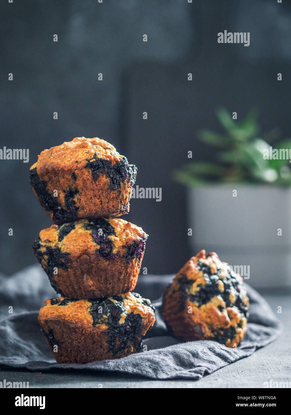 In casa vegan muffin ai mirtilli su sfondo scuro. Pila di tre uova muffin gratis con copia spazio per il testo o il design. Tasto basso. Verticale. Foto Stock