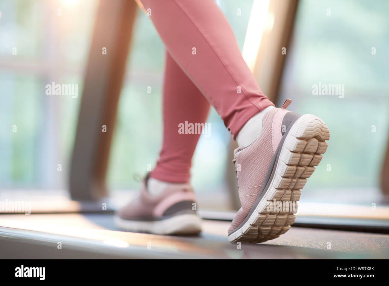 Vista dettagliata del piede femminile in esecuzione sul tapis roulant durante il cardio allenamento in palestra, spazio di copia Foto Stock