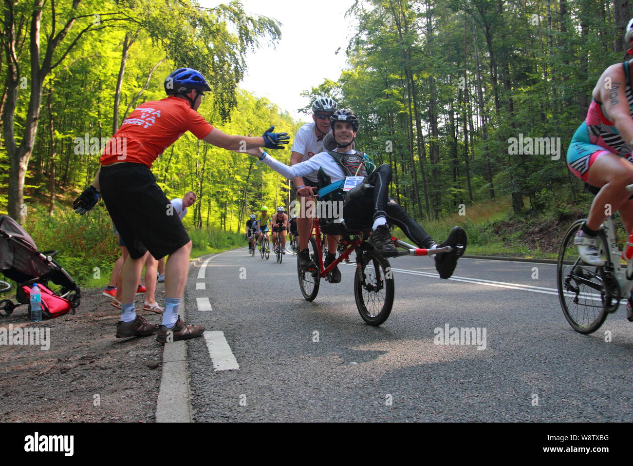 Gdynia, Polonia, luglio 11, 2019: i concorrenti sulla Enea Ironman 70,3 Gdynia percorso in bicicletta. Le ventole fortemente rallegrato per i partecipanti della gara Foto Stock