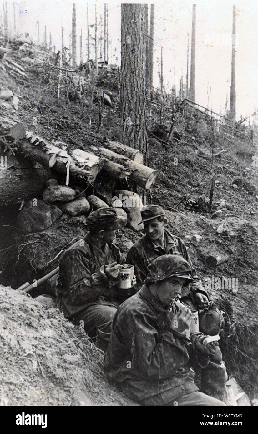 Waffen SS truppe nel camuffamento di camici e cappucci di prendere una pausa pranzo sul fronte russo 1943 Foto Stock