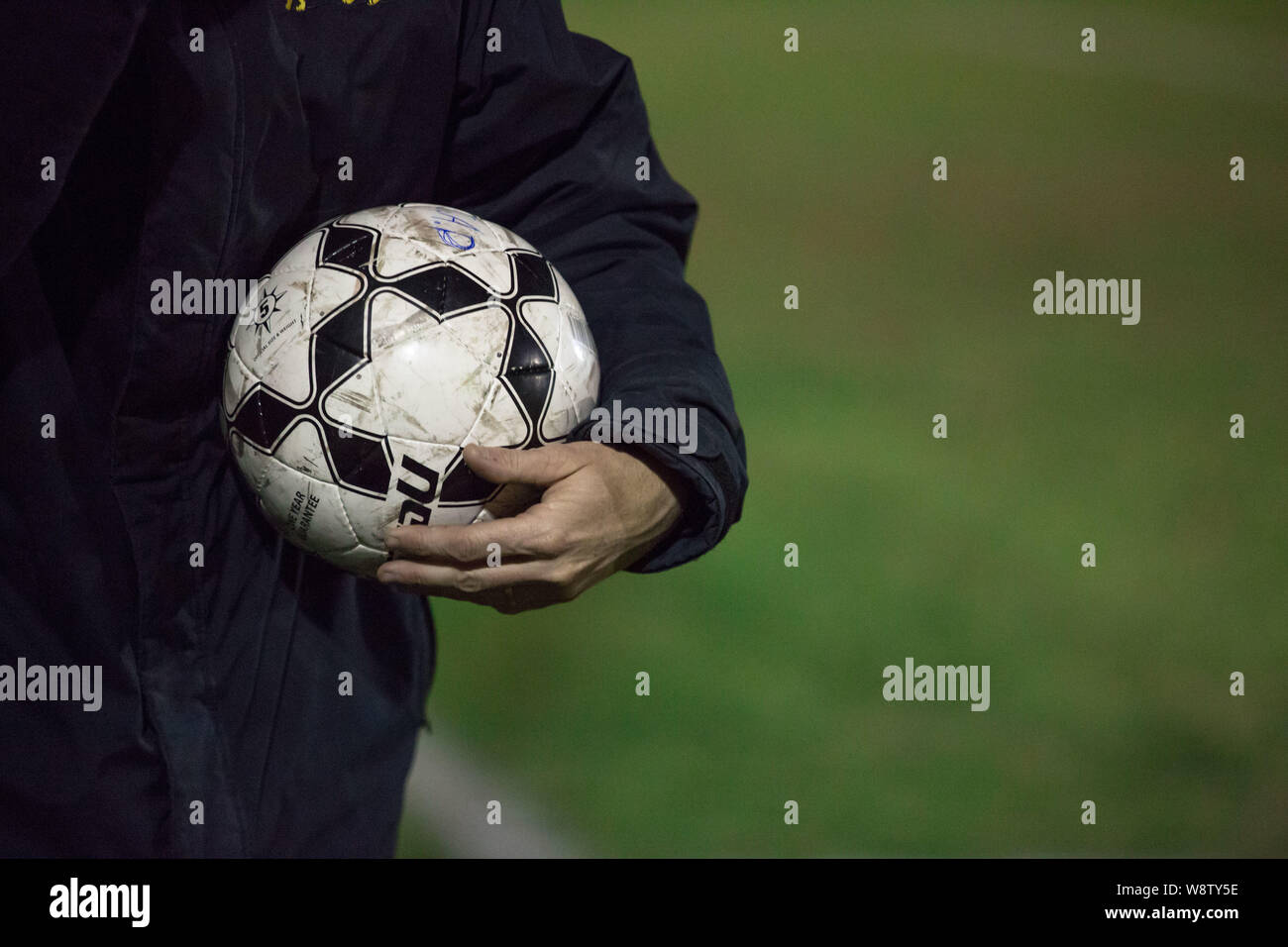 Un uomo detiene una partita di football soccer ballom su una corte Foto Stock