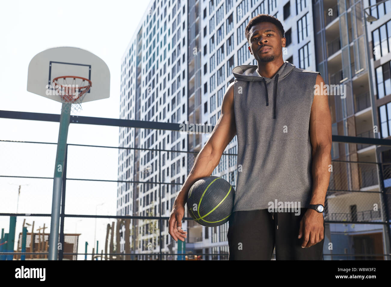 Ritratto di afro-americano di giocatore di basket in piedi guardando la fotocamera in tribunale aperto, spazio di copia Foto Stock