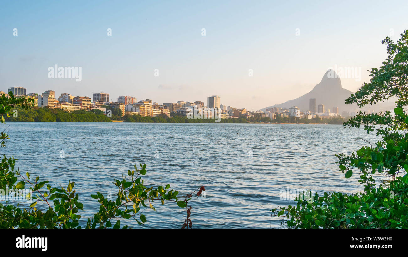 Vista panoramica (16x9) paesaggio della laguna Rodrigo de Freitas a Rio de Janeiro compresi Dois Irmaos Mountain e alcune facciate di edifici Foto Stock