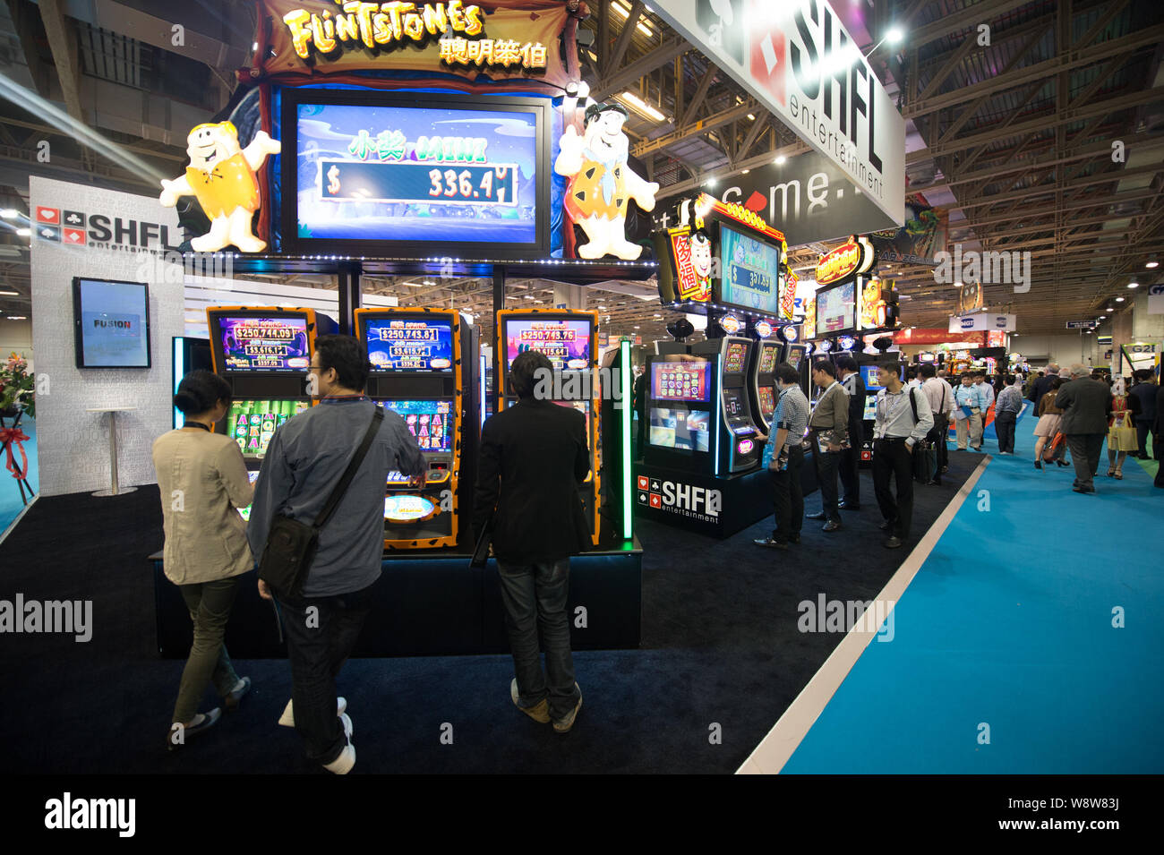 --FILE--i visitatori di provare le slot machines durante il settimo Global Gaming Expo Asia (G2E Asia 2013) a Macau, Cina, 22 maggio 2013. Gioco d'azzardo entrate in Maca Foto Stock