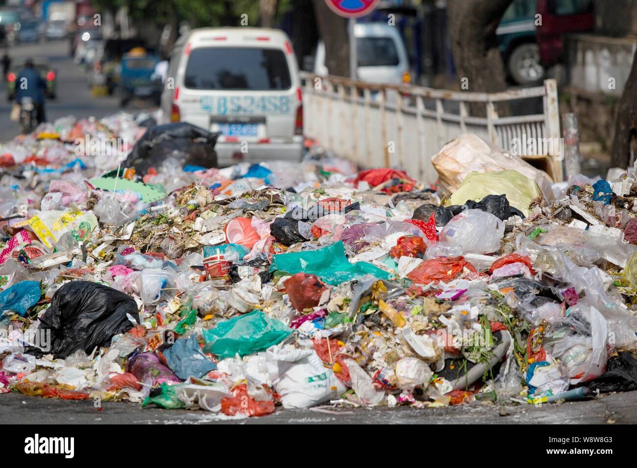 Un minivan è circondato da cumuli di rifiuti a sinistra su una strada in città Shiyan, città di Shenzhen, Cina del sud della provincia di Guangdong, 20 novembre 2014. Cina Foto Stock