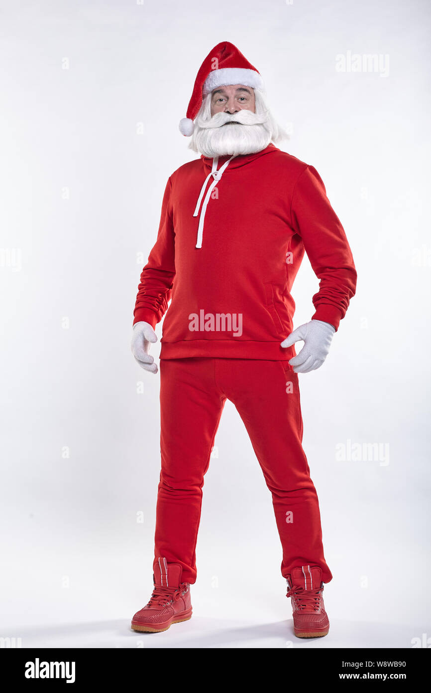 Ritratto di un Babbo Natale in rosso sportsware in piena crescita. Bianco-dai capelli uomo anziano con barba e baffi cercando nella fotocamera. Foto Stock