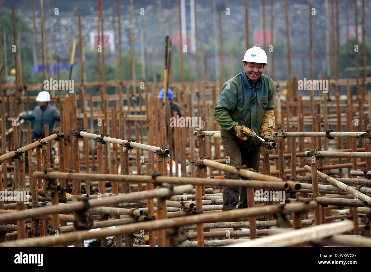 --FILE--cinese lavoratori migranti costruire impalcature presso il cantiere per la costruzione di un immobile commerciale progetto nella città di Jiujiang, est Chinas Jiangxi pro Foto Stock