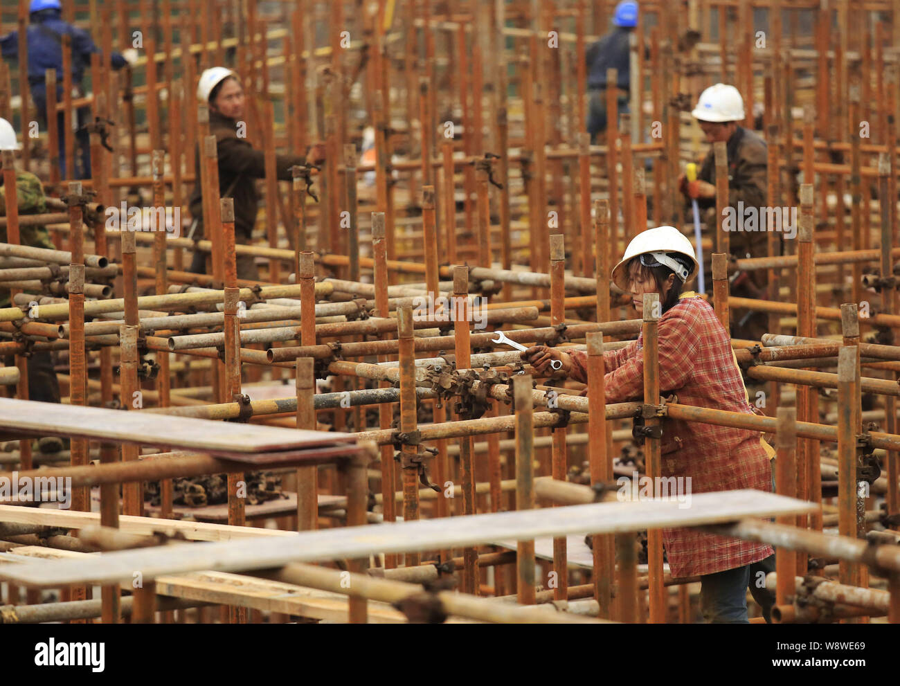 --FILE--cinese lavoratori migranti costruire impalcature presso il cantiere per la costruzione di un immobile commerciale progetto nella città di Jiujiang, est Chinas Jiangxi pro Foto Stock