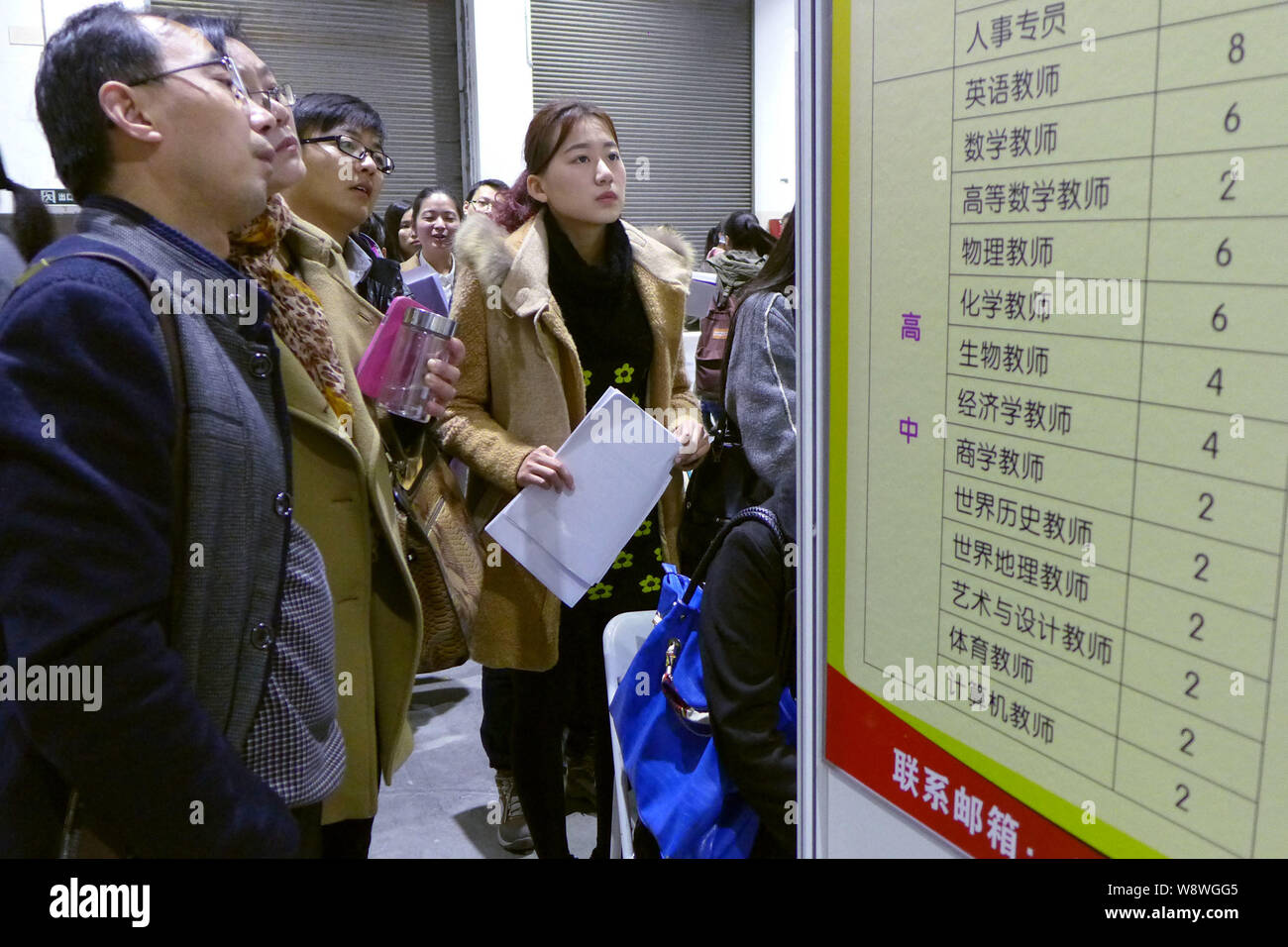 --FILE--laureati cinesi guardare le informazioni di lavoro a una fiera del lavoro in Cina a Shanghai, 29 novembre 2014. La Cina del mercato del lavoro ha dimostrato una buona tenuta des Foto Stock