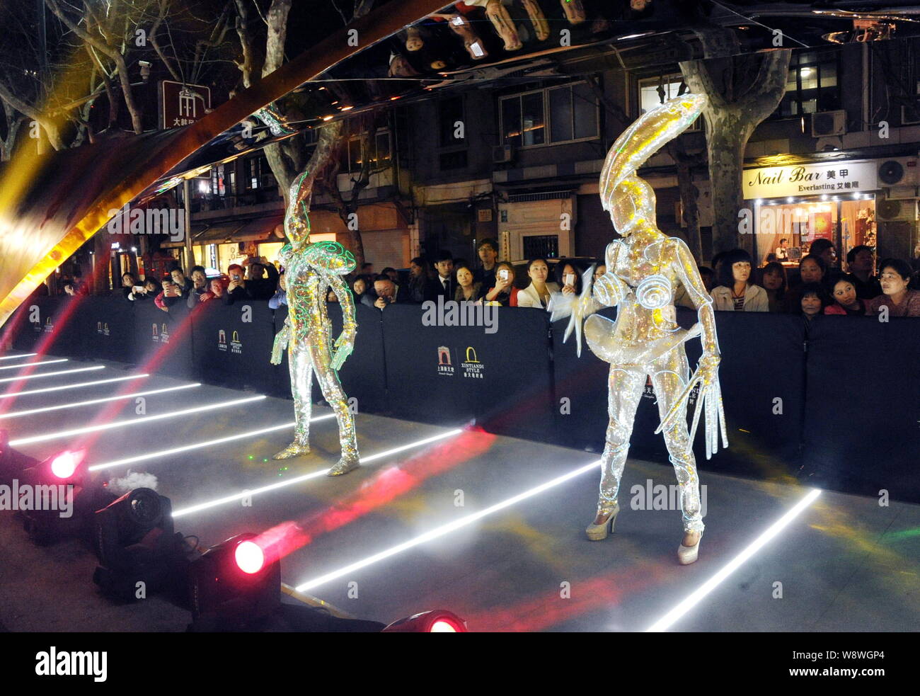 Gli animatori vestito in alieno-costumi stile eseguire durante la fase di progettazione il tuo stile crossover la finestra di visualizzazione mostra a Xintiandi a Shanghai in Cina, Foto Stock