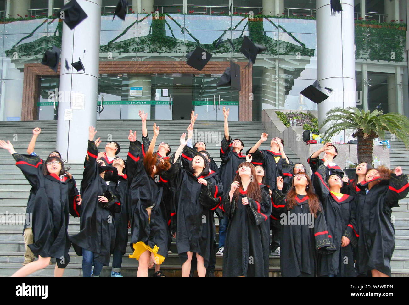 FILE--laureati cinesi vestito in abiti di maturità buttare i loro cappelli  in aria durante una cerimonia di laurea a Zhejiang A&F University in Hang  Foto stock - Alamy