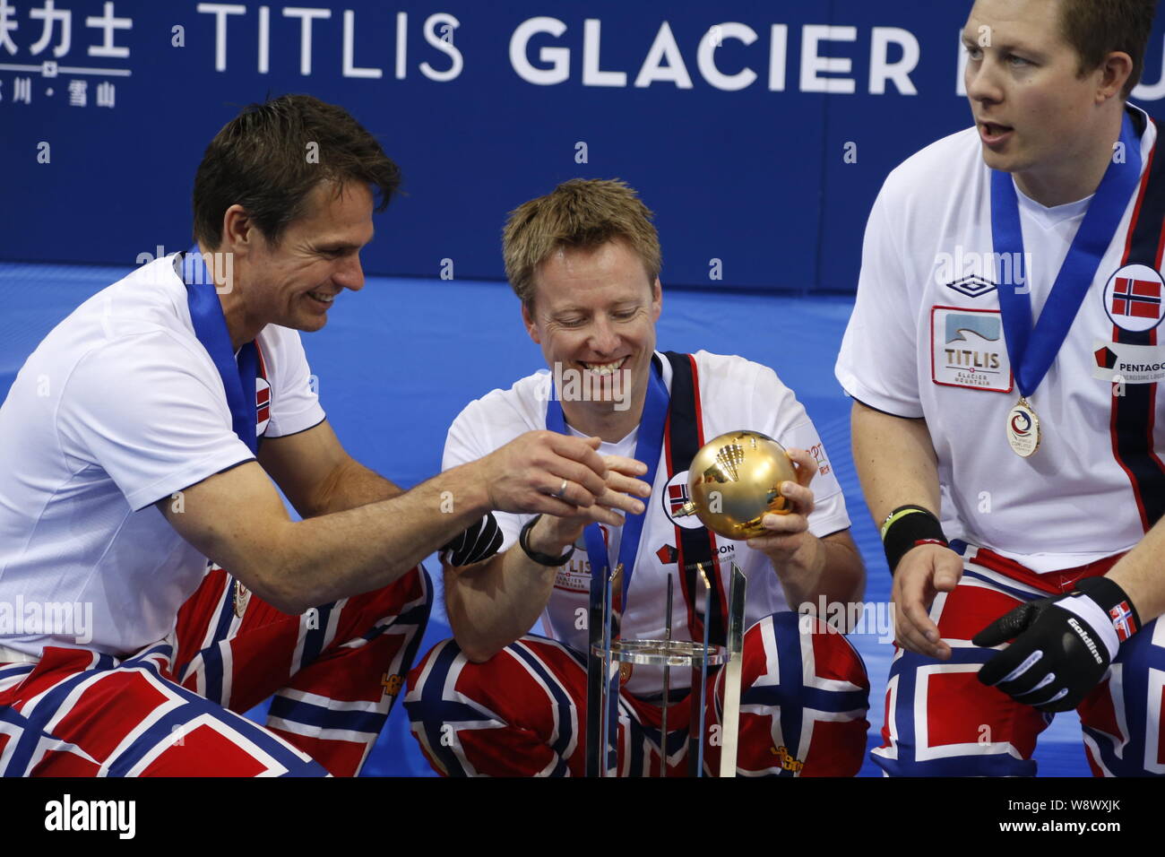 Arricciacapelli Thomas Ulsrud, sinistra e Torger Nergard, centro, provare a mettere di nuovo la palla il loro campione del trofeo sul podio dopo aver vinto il mondo Mens Foto Stock