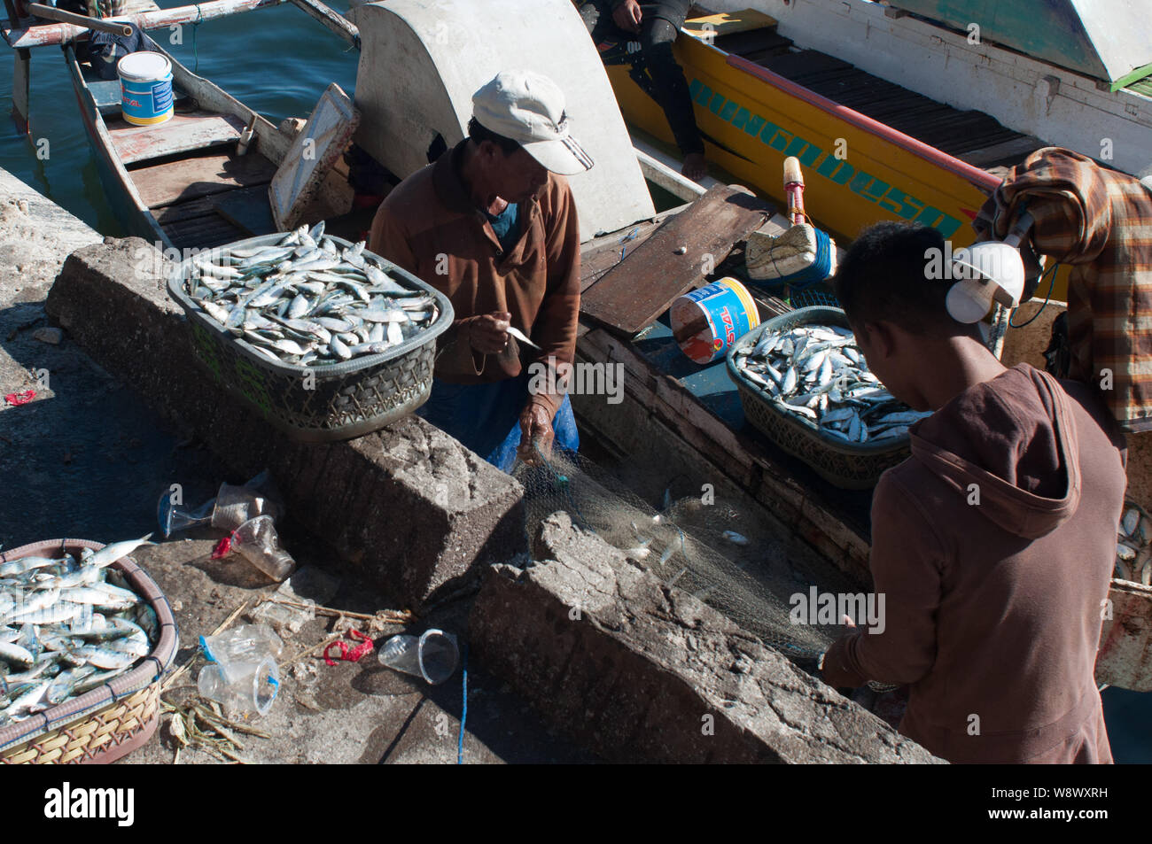 Pescatori scaricano ceste piene og harrings Paotere al mercato del pesce di Makasar. L' Indonesia è diventata uno dei più grandi pesci prodotto dopo la centrale di andare Foto Stock