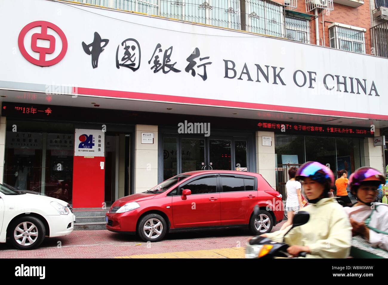 --FILE--ciclisti ride passato una filiale della Banca di Cina (BOC) nella città di Xuchang, porcellane centrale provincia di Henan, 23 giugno 2013. La Banca di Cina ha firmato un Foto Stock