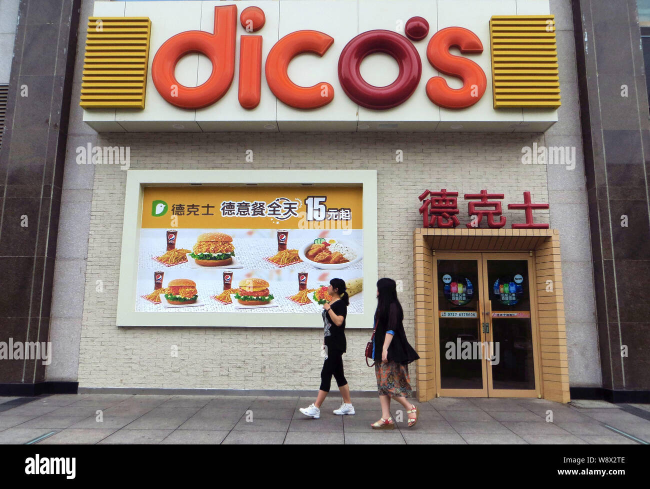 --FILE--pedoni a piedi passato un Dicos un fast food ristorante a Yichang city, porcellane centrale provincia di Hubei, 27 giugno 2014. Cibo cinese sono le catene ai Foto Stock