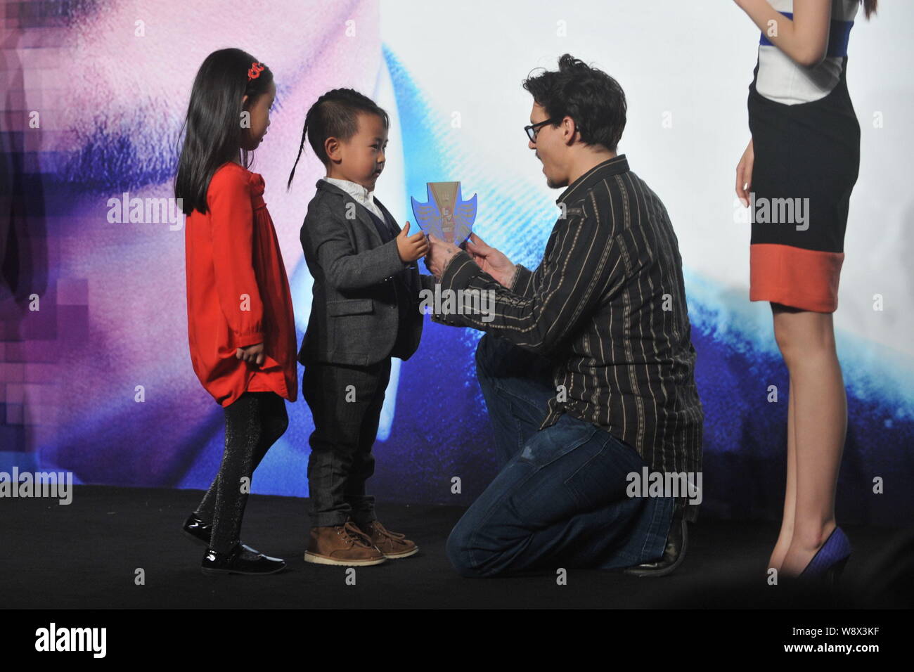 Attore americano Johnny Depp, seconda a destra, riceve un regalo da due giovani bambini in occasione di una conferenza stampa per il suo film, trascendenza, a Pechino, in Cina, 3 Foto Stock