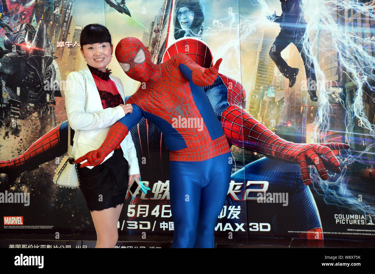 Un animatore vestito in Spider-man costume pone con un filmgoer davanti a un poster del film, The Amazing Spider-Man 2, in un cinema di Wen Foto Stock