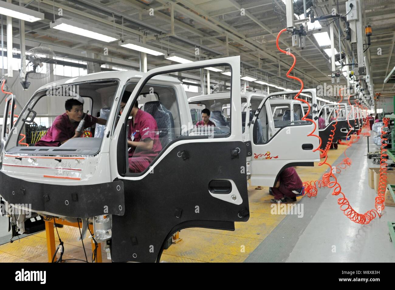 --FILE--lavoratori cinesi assemblare camion sulla linea di montaggio presso l'impianto automatico di Anhui Jianghuai Automobile Co., Ltd. (JAC) nella città di Qingzhou, est ch Foto Stock