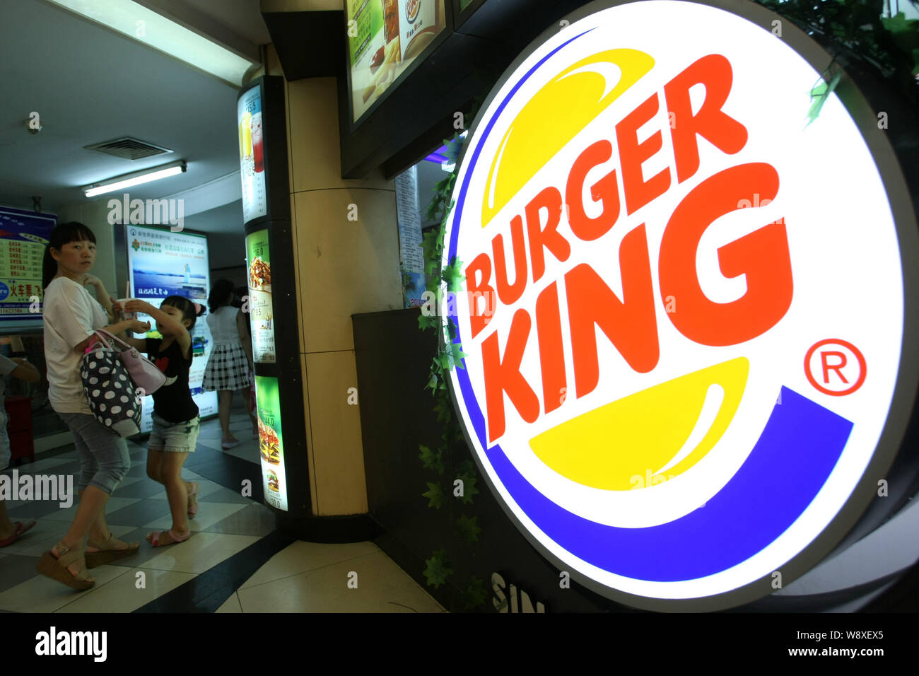 I pedoni a piedi passato un fast-food di Burger King in Cina a Shanghai, 23 luglio 2014. Burger King Worldwide Inc., reagire a un rischio sanitario Foto Stock