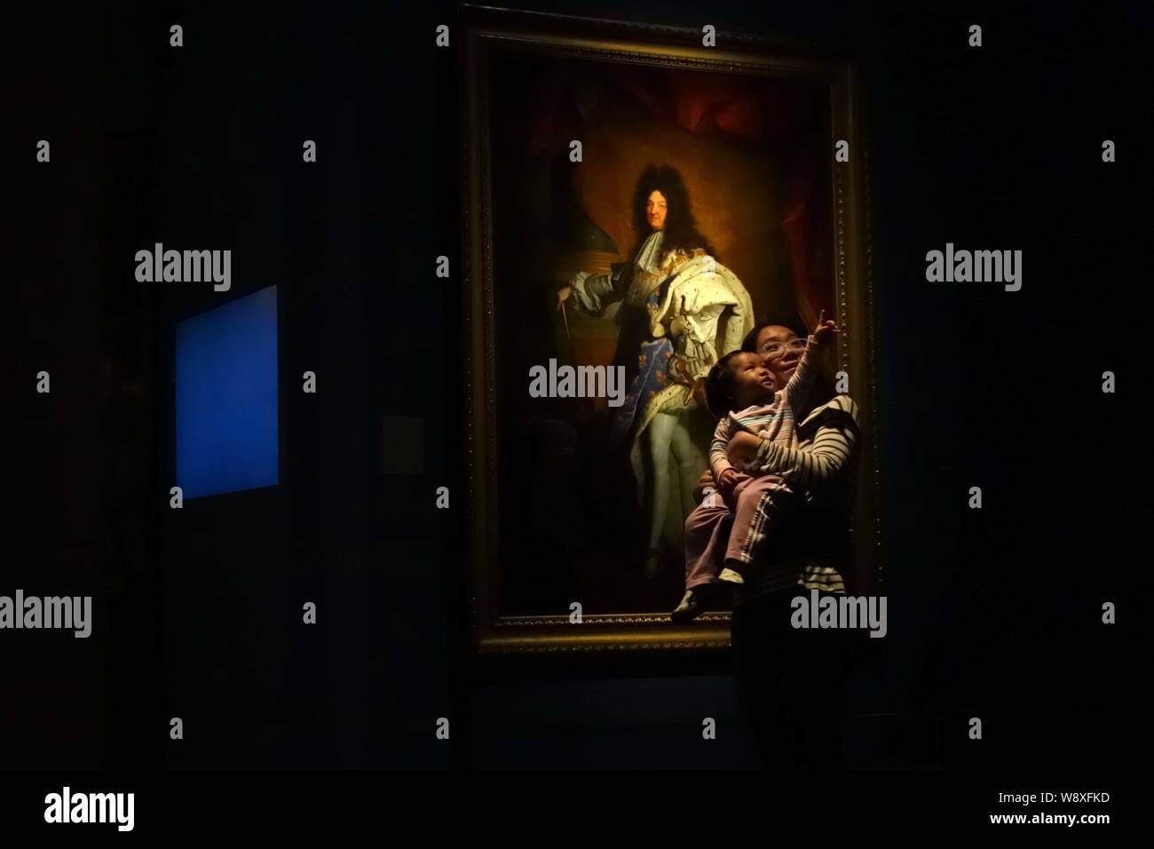 Un visitatore cinese portando la sua figlia è visibile nella parte anteriore della pittura, Luigi XIV, dall artista francese Hyacinthe Rigaud Il duomo, durante una mostra a mark t Foto Stock