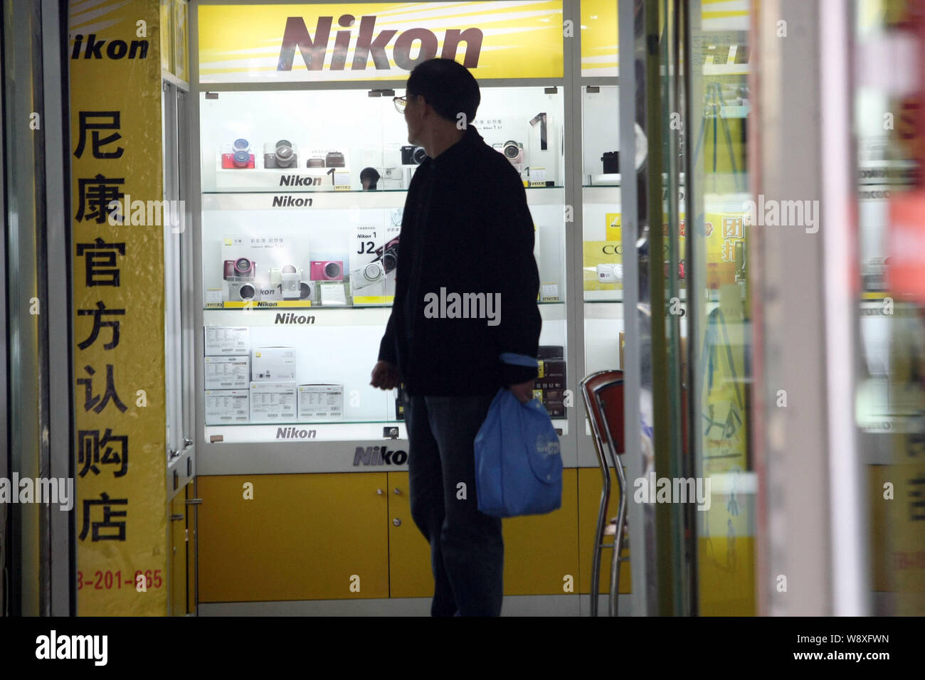 Un cliente negozi per fotocamere digitali Nikon presso un negozio di Nikon in Cina a Shanghai, 17 marzo 2014. Chinas potente controllato dal governo broa televisione Foto Stock