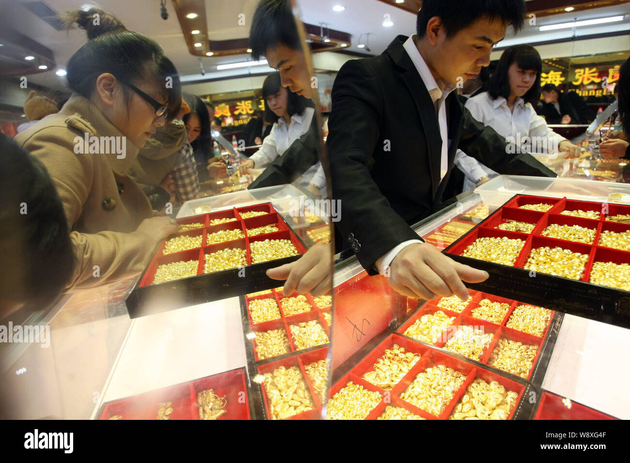 --FILE--i clienti cinesi shop per ornamenti d'oro presso un negozio gioielli in Cina a Shanghai, 2 gennaio 2014. La Cina ha sorpassato l'India come i mondi lar Foto Stock