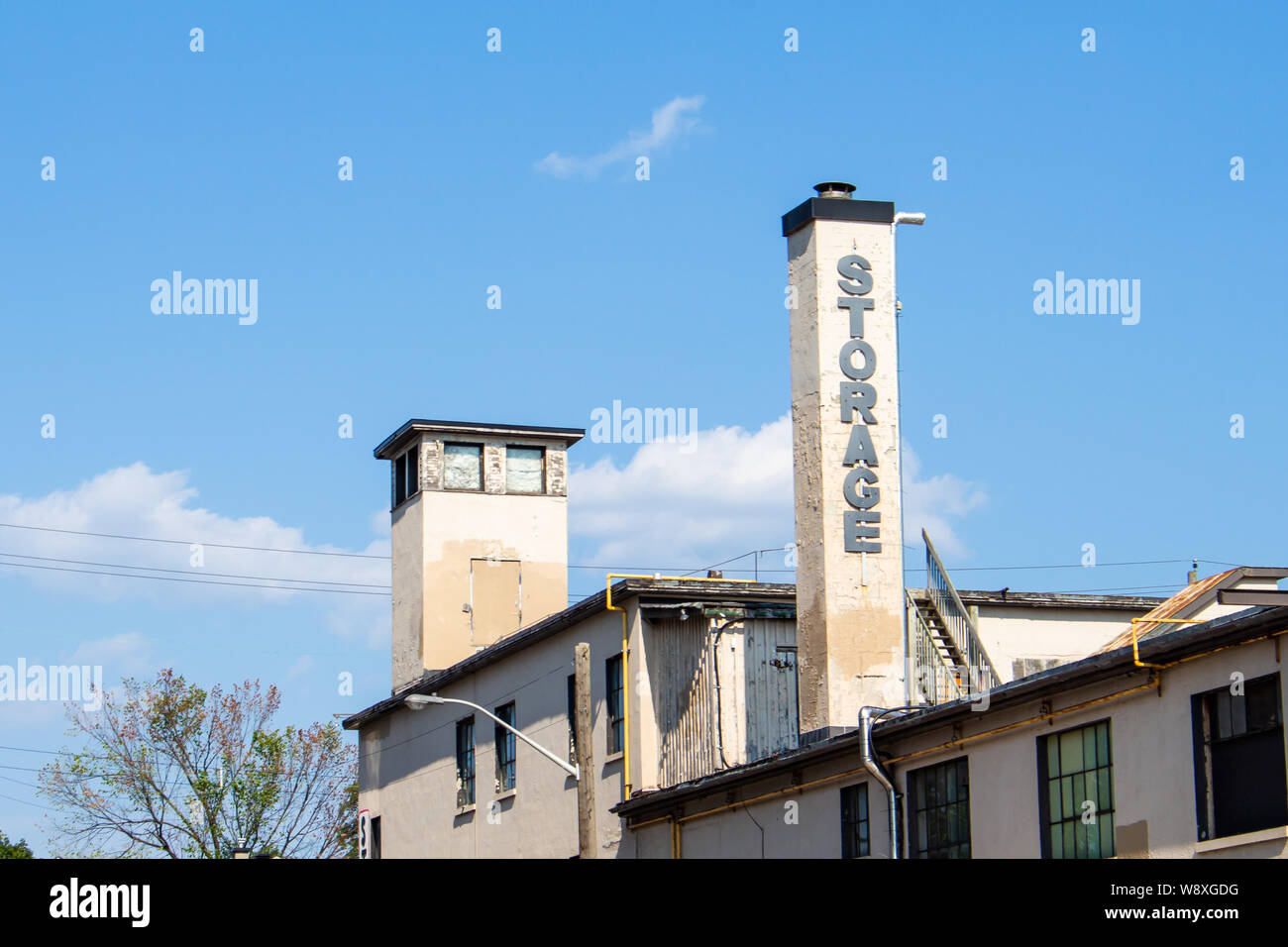 La parola 'Storage' è scritto nel blocco di scritte sul camino di un edificio di invecchiamento, di cui la metà superiore è visibile contro il cielo blu. Foto Stock