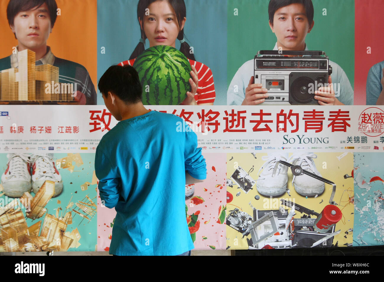 --FILE--un moviegoer guarda un poster per il filmato e così giovane, in un cinema a Shanghai in Cina, il 2 maggio 2013. Ke la calcinazione, il 32-anno-vecchio produttore di ch Foto Stock