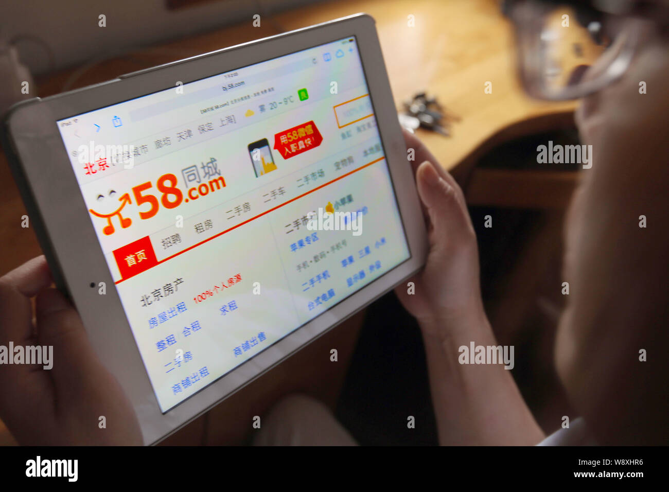 --FILE--un cinese netizen accede al sito web di 58.com sul suo iPad in Cina a Shanghai, 2 ottobre 2014. Tencent Holdings Ltd, la Cina la seconda più grande Foto Stock