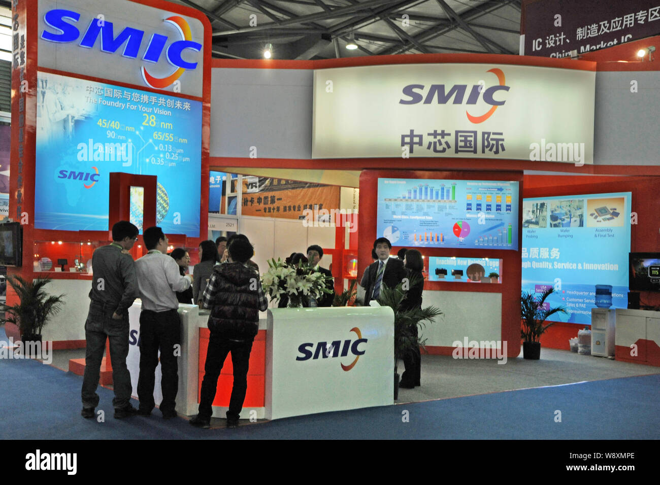 --FILE -- la gente visita lo stand del SMIC (Semiconductor Manufacturing International Corporation) durante il SEMICON China 2014 mostra a Shanghai, C Foto Stock