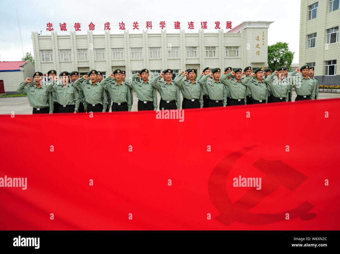 Soldati cinesi giurare davanti alla bandiera del Partito Comunista della Cina (CPC) durante un giuramento in occasione della cerimonia per il prossimo 88° anniversario della Foto Stock