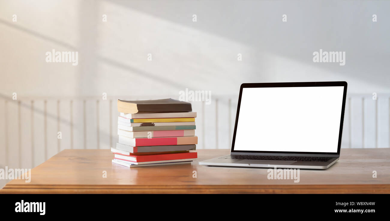 Aprire lo schermo è vuoto portatile con una pila di libri in camera confortevole Foto Stock