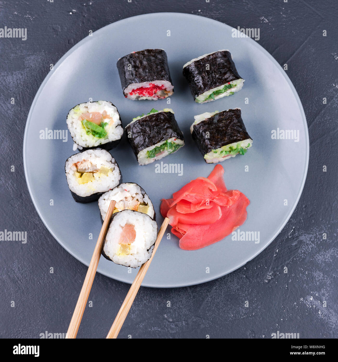 Rotolo di Sushi con bacchette grande su una piastra di sfondo rotoli con vista superiore Foto Stock