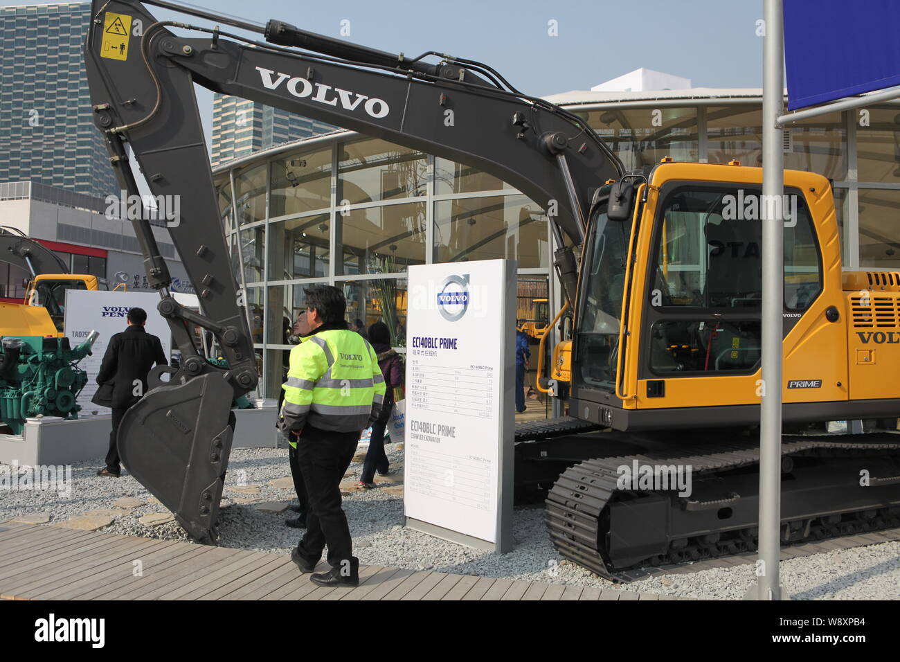 --FILE--un dipendente cinese passeggiate passato un escavatore Volvo prodotta da Volvo Construction Equipment durante il 2010 Fiera Internazionale per cons Foto Stock