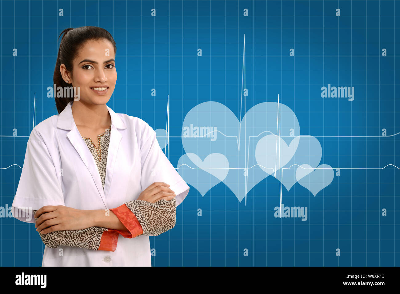 Medico donna sorridente con le braccia incrociate Foto Stock