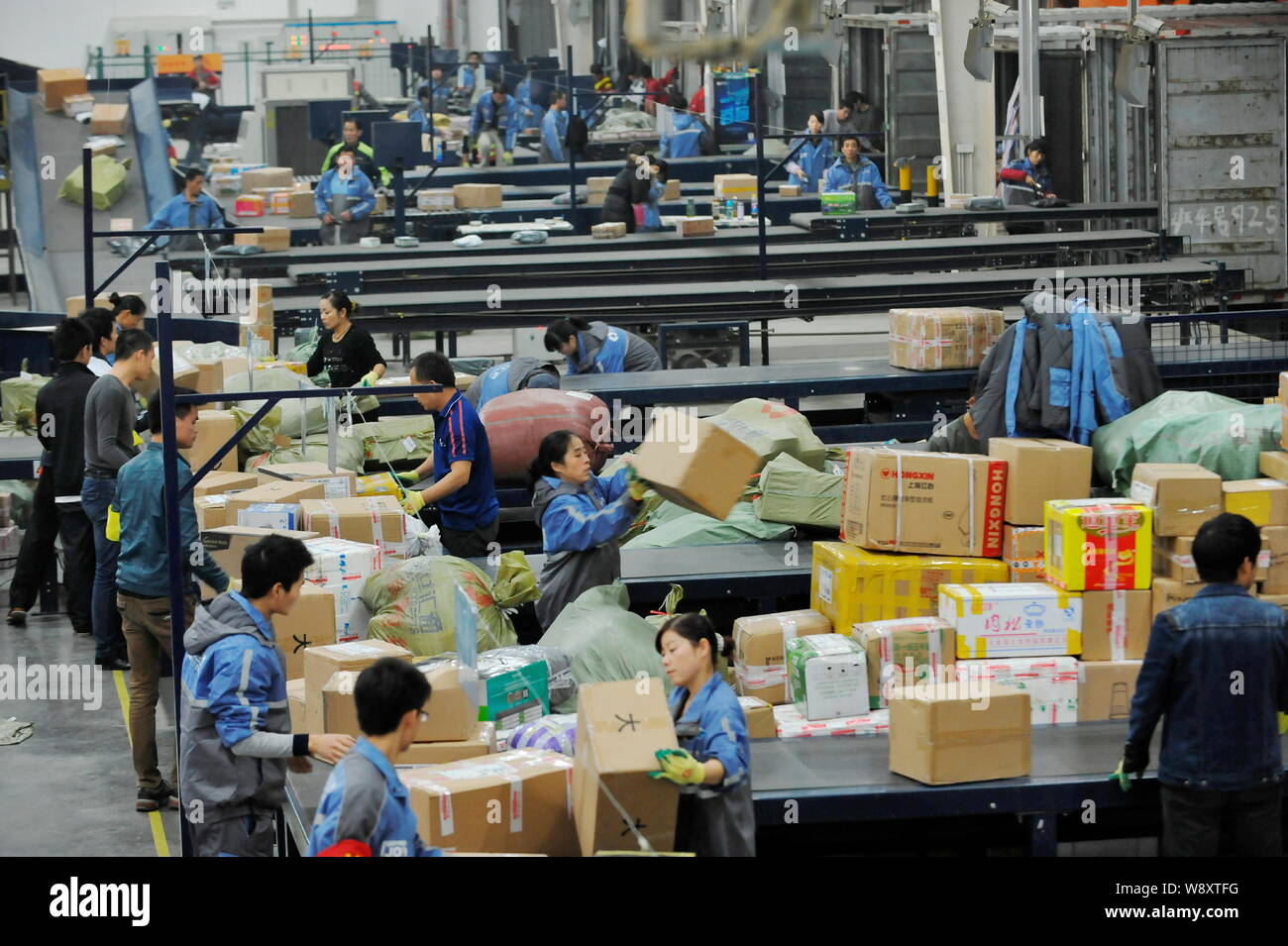 Lavoratori cinesi ordinamento pacchi, la maggior parte dei quali sono da shopping  online, presso un centro di distribuzione di un corriere nella città di  Wuhan, Cina centrale di hub Foto stock -